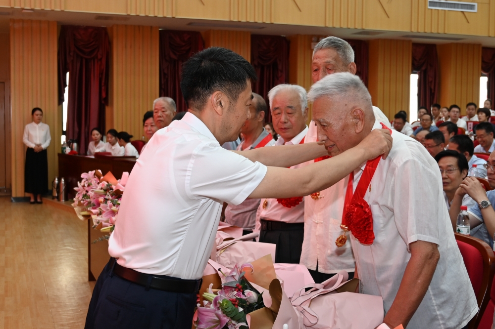 校党委书记王洪彬为“光荣在党50年”党员代表颁发纪念章